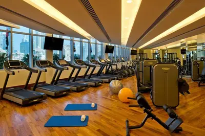 a gym with a row of treadmills and machines at Suitestay-Formerly Address Dubai Mall Residence-Downtown in Dubai