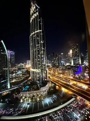 a city skyline at night with a tall building at Suitestay-Formerly Address Dubai Mall Residence-Downtown in Dubai