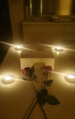 a box with three roses sitting next to lights at Suitestay-Formerly Address Dubai Mall Residence-Downtown in Dubai