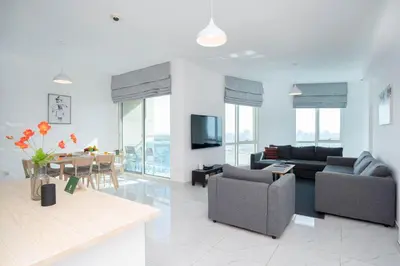 a living room with two couches and a dining room at Budget Friendly Production City in Dubai
