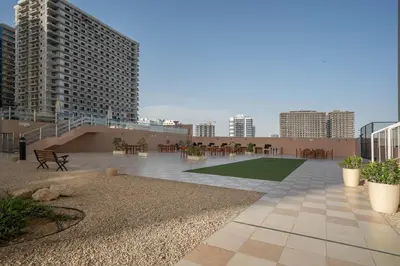 a rooftop patio with tables and chairs and buildings at Budget Friendly Production City in Dubai
