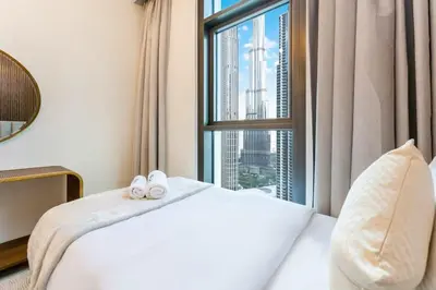 a bedroom with a bed and a large window at FAM Living - Modern 3 Beds+Maidroom Home in Downtown Burj view in Dubai