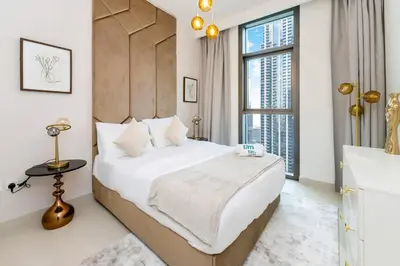 a bedroom with a bed and a large window at FAM Living - Modern 3 Beds+Maidroom Home in Downtown Burj view in Dubai