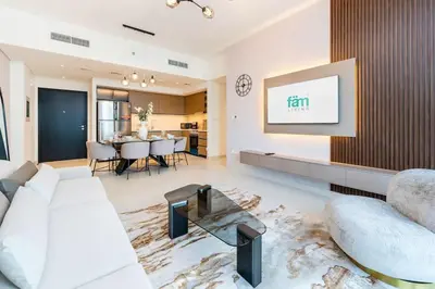 a living room with a white couch and a tv at FAM Living - Modern 3 Beds+Maidroom Home in Downtown Burj view in Dubai
