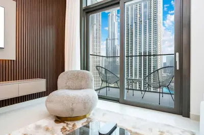 a living room with a chair and a balcony at FAM Living - Modern 3 Beds+Maidroom Home in Downtown Burj view in Dubai