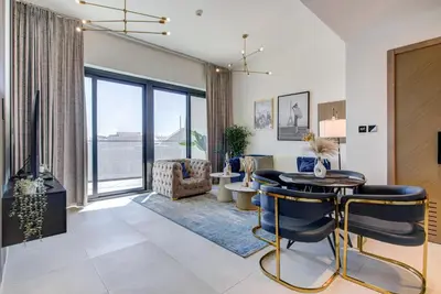 a living room with a table and chairs at Serene City Stays Binghatti Canal Luxe 2BR in Dubai