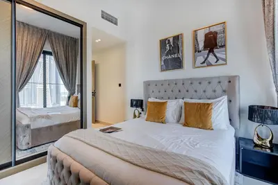 a bedroom with a large bed and a mirror at Serene City Stays Binghatti Canal Luxe 2BR in Dubai