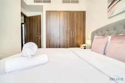 a bedroom with a large white bed with pink pillows at Exquisite 4BR Townhouse at DAMAC Hills 2, Dubailand by Deluxe Holiday Homes in Dubai