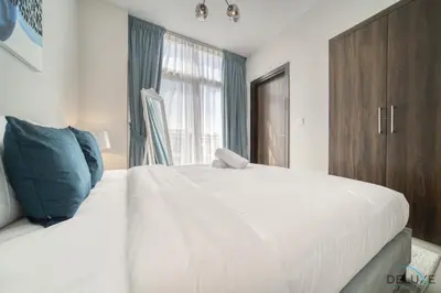 a bedroom with a large white bed and a window at Exquisite 4BR Townhouse at DAMAC Hills 2, Dubailand by Deluxe Holiday Homes in Dubai