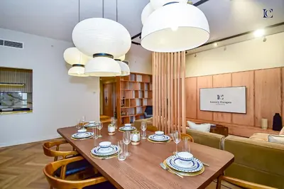 a dining room with a table and two chandeliers at Luxury Escapes - Charming 3BR plus maids Apt near JBR Beach - Sadaf 1 in Dubai