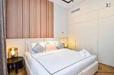 a bedroom with a large white bed and a table at Luxury Escapes - Charming 3BR plus maids Apt near JBR Beach - Sadaf 1 in Dubai