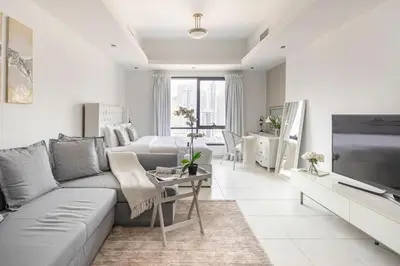 a living room with a couch and a tv at Frank Porter - Al Waleed Paradise in Dubai