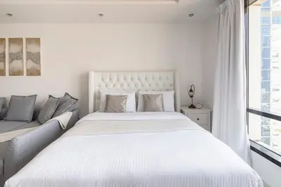a white bedroom with a large bed and a couch at Frank Porter - Al Waleed Paradise in Dubai