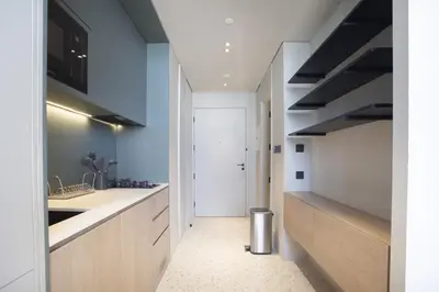 a kitchen with white counters and a door to a hallway at Studio with Burj Khalifa View - Upside Living in Dubai