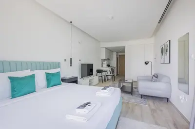 a bedroom with a large bed and a living room at Ahad Residences Studio- 15mins walk to Dubai Mall in Dubai