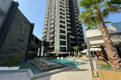 a hotel swimming pool with chairs and a tall building at Ahad Residences Studio- 15mins walk to Dubai Mall in Dubai