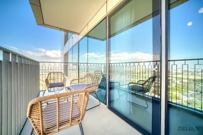 a balcony with wicker chairs and a view of the city at Exquisite 1BR at Downtown Views II Tower 2 Downtown Dubai by Deluxe Holiday Homes in Dubai