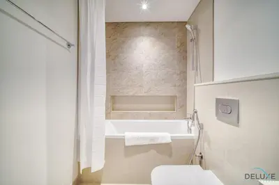 a bathroom with a white tub and a toilet at Exquisite 1BR at Downtown Views II Tower 2 Downtown Dubai by Deluxe Holiday Homes in Dubai