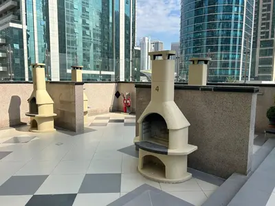 a rooftop patio with a pizza oven on a building at StoneTree - Cozy Studio - JLT in Dubai