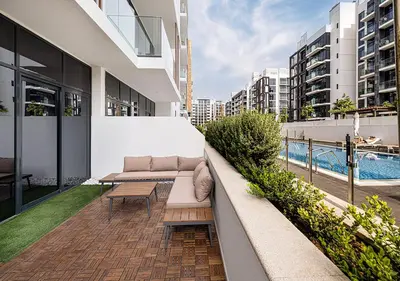 a balcony with a couch and a table on a building at 1BR Gem with Pool 15 Mins to Downtown Dubai in Dubai