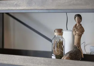 a glass bottle sitting on a shelf next to a candle at 1BR Gem with Pool 15 Mins to Downtown Dubai in Dubai