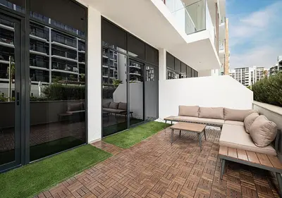 a couch sitting on a patio in a building at 1BR Gem with Pool 15 Mins to Downtown Dubai in Dubai
