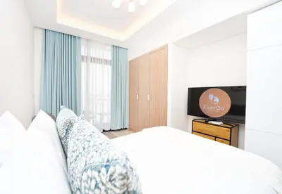 a bedroom with a bed and a flat screen tv at EasyGo - Azizi Riviera 9 Bright Studio in Dubai