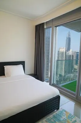 a bedroom with a white bed and a large window at Magnificent 3BR with Incredible Burj & Fountain View in Dubai