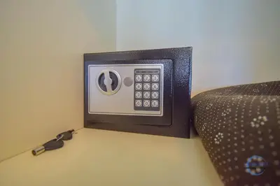 a clock on a wall next to a couch at Burj Vista Burj Khalifa Metro & Mall Access in Dubai