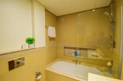 a bathroom with a tub and a glass shower at Burj Vista Burj Khalifa Metro & Mall Access in Dubai