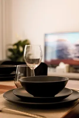 a table with a bowl and a wine glass at Dubaistay Luxury 2 Bedroom holiday appartment JVC KING and QUEENSIZE in Dubai