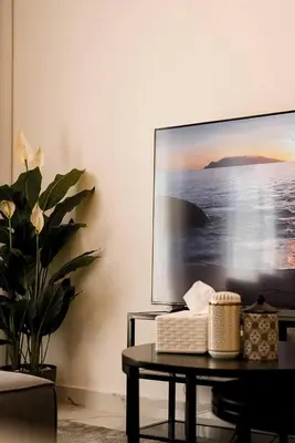 a living room with a tv and a table at Dubaistay Luxury 2 Bedroom holiday appartment JVC KING and QUEENSIZE in Dubai