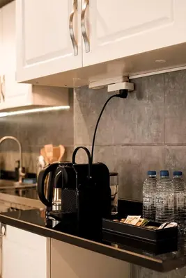 a kitchen counter with a tea kettle and water bottles at Dubaistay Luxury 2 Bedroom holiday appartment JVC KING and QUEENSIZE in Dubai