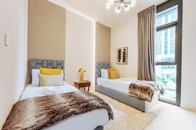a bedroom with two beds and a window at Stayis l 2BR Iconic Burj Khalifa View Partial in Dubai