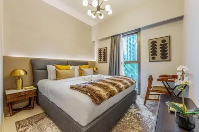 a bedroom with a large bed and a window at Stayis l 2BR Iconic Burj Khalifa View Partial in Dubai
