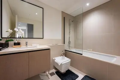 a bathroom with a toilet and a sink and a tub at Stayis l 2BR Iconic Burj Khalifa View Partial in Dubai