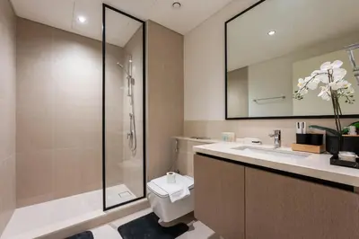 a bathroom with a shower and a toilet and a sink at Stayis l 2BR Iconic Burj Khalifa View Partial in Dubai