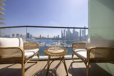 a balcony with chairs and a table and a view of the city at 2BR Emaar Beachfront with Full Sea & Skyline Views in Dubai