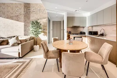 a kitchen and a living room with a table and chairs at Emaar Beachfront - Beach Isle Tower 2, Dubai Marina in Dubai
