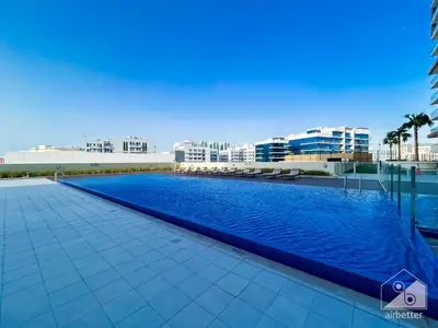 a swimming pool on the roof of a building at Stunning studio with Balcony in Arjan in Dubai