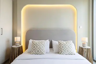 a bedroom with a large white bed with two lamps at Burj Khalifa View, High Floor, Dubai Mall Access, Gym, Infinity-Pool, Playground, BBQ, Family Friendly in Dubai