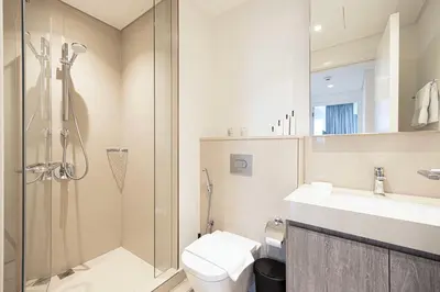 a bathroom with a shower and a toilet and a sink at Burj Khalifa View, High Floor, Dubai Mall Access, Gym, Infinity-Pool, Playground, BBQ, Family Friendly in Dubai