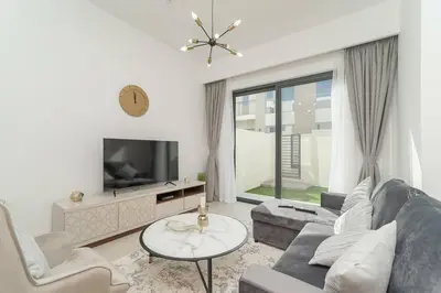 a living room with a couch and a tv at Luxurious 3 BR with Maid Room in Arabian Ranches 2 in Dubai