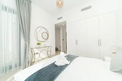 a white bedroom with a large bed and a mirror at Luxurious 3 BR with Maid Room in Arabian Ranches 2 in Dubai