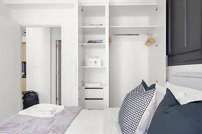 a bedroom with a bed and white walls at Silkhaus Comfy 1BR by Burj Khalifa with Balcony in Dubai
