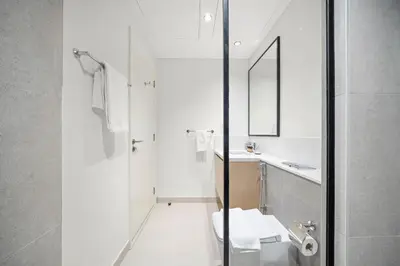 a white bathroom with a toilet and a sink at Silkhaus Comfy 1BR by Burj Khalifa with Balcony in Dubai