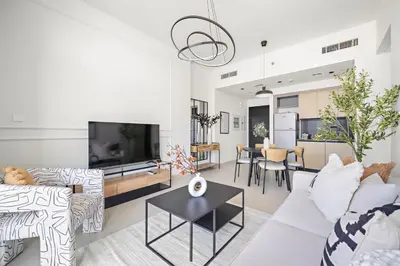 a living room with white furniture and a flat screen tv at Silkhaus Comfy 1BR by Burj Khalifa with Balcony in Dubai
