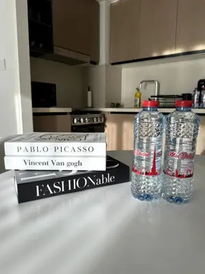 two bottles of water sitting on a counter next to two books at Burj Crown - Luxury Apartment Near Burj Khalifa in Dubai