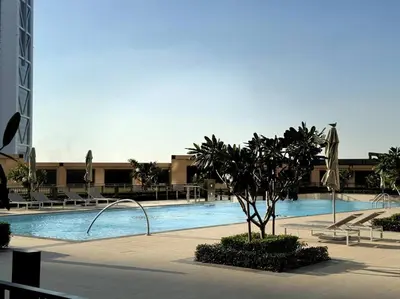 a large swimming pool with a palm tree in front of a building at Burj Crown - Luxury Apartment Near Burj Khalifa in Dubai