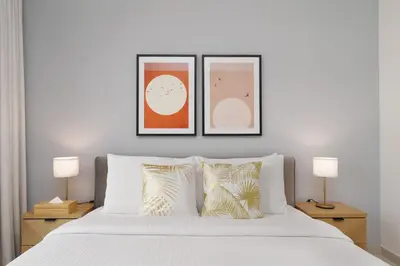 a bedroom with three framed pictures above a bed at Maison Privee - Modern Chic Apt with Unobstructed Burj Khalifa Views in Dubai